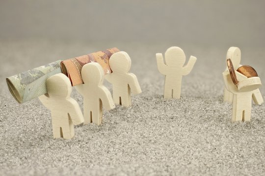 Darstellung Reich Arm mit Figuren aus Holz und Geldscheinen sowie Centm&uuml;nzen