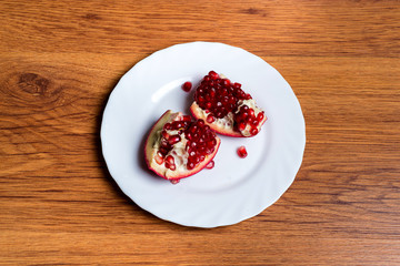 Pomegranate slices and garnet fruit seeds on table. Pomegranate whole. Useful fruit.