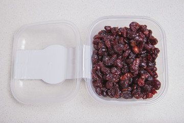 Transparent plastic bowl full of dried blueberry