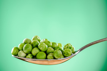 peas on a spoon - green bacground