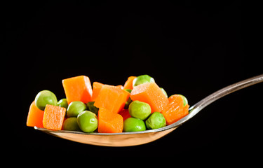peas and carrots on a spoon