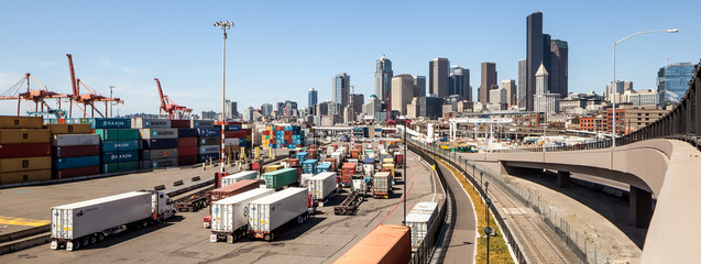 Panorama of trucks entering Seattle harbor with skyline in background