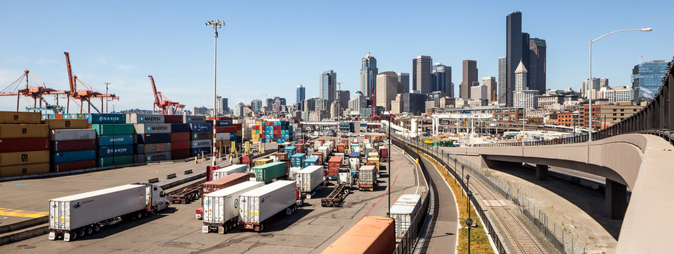 Panorama Of Trucks Entering Seattle Harbor With Skyline In Background