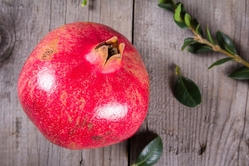 Some whole red pomegranate on rustic wooden unpainted table