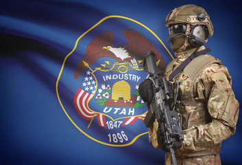 Soldier in helmet holding machine gun with USA state flag on background series - Utah