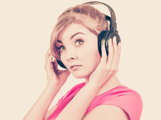 Woman sad girl in big headphones listening music