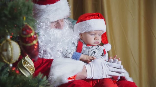 Closeup of a santa playing with a small child