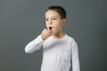 Bad breath. Halitosis concept. Child checking his breath with his hand.