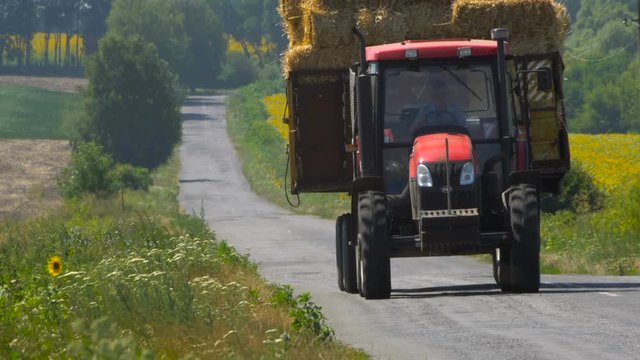 Tractor with straw bales going on the road