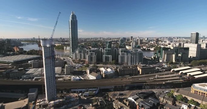 Aerial descending view of contemporary riverside development and skyscrapers by the river Thames in London
