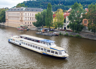 Naklejka premium Tourist boat cruise on Vltava river in Prague.
