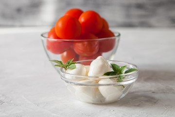 ingredients for salad - cheese, a tomato, olives and oil. selective focus