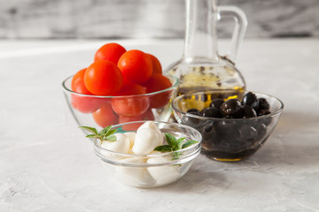 ingredients for salad - cheese, a tomato, olives and oil. selective focus