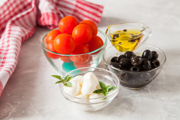 ingredients for salad - cheese, a tomato, olives and oil. selective focus