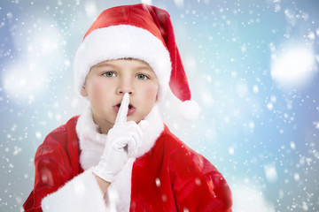 boy dressed up as Santa in winter setting