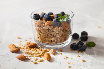 muesli with almonds and blueberry in a glass on a table, selective focus