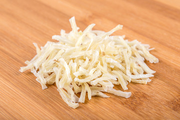 Sliced dried potatoes isolated on wood background