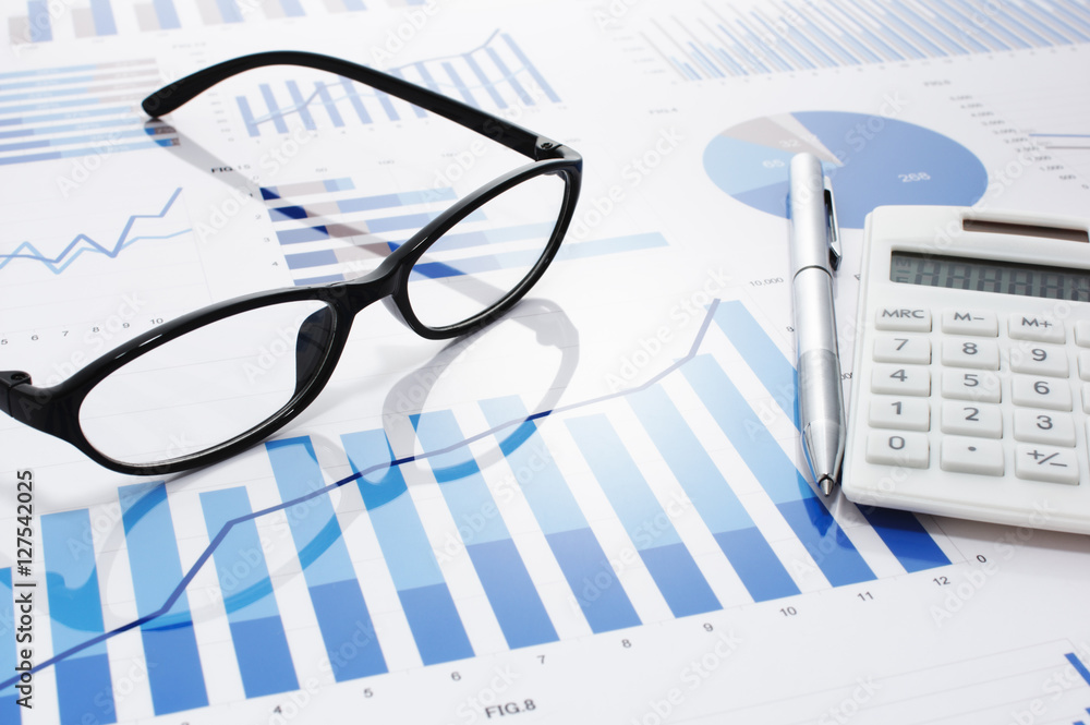 Poster many graphs, charts, glasses, calculator and pen on reflection background. reviewing business data.