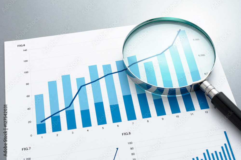 Poster document, charts and magnifying glass on gray reflection background. reviewing business report. look