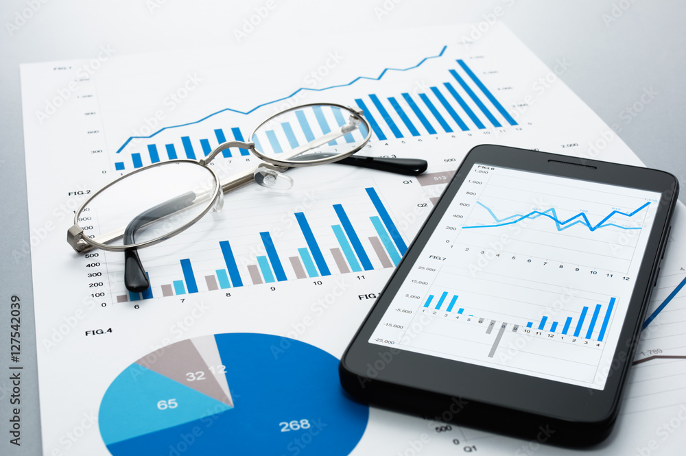 Poster Business document, glasses and smart phone on gray reflection background.
Many graphs and charts. Concept image of data reviewing.
