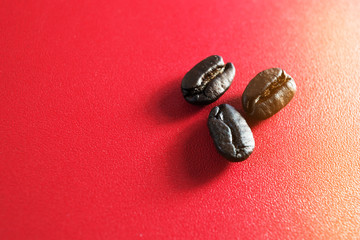 selective focus three coffee beans on the red background