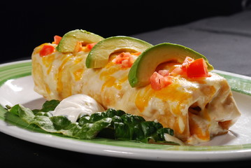 Wet burrito with cheese , avocado and pico de gallo