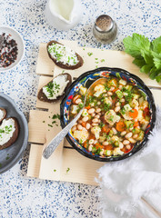 Vegetarian vegetable soup and cheese sandwiches on a light background, top view