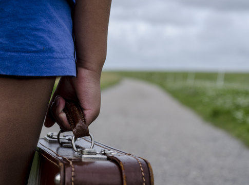 Girl standing with her suitcase going away