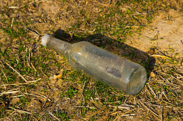 old abandoned glass bottle left open stores stagnant water. potential mosquitoes breeding ground.