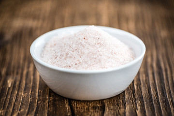 Portion of Himalayan Salt on wooden background (selective focus)