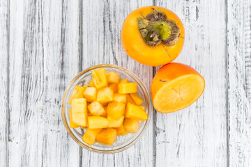 Wooden table with Kaki fruits (selective focus)