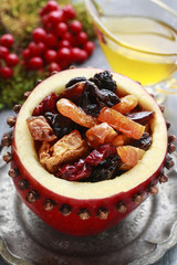 Red christmas apple stuffed with dried fruits in honey