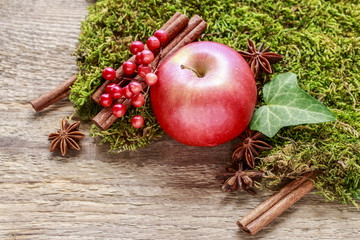 Traditional christmas decoration with red apple, cinnamon sticks