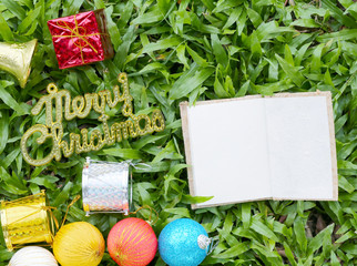 Red Gift box and empty note paper on green lawn and have gold te