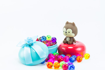 Teddy bear on red blue gift box and color plastic balls on  whit