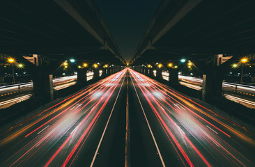 Fototapeta na wymiar Fast moving traffic with red light trails on black asphalt motorway