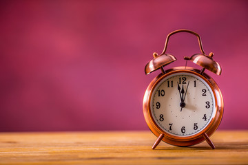 Retro alarm clock with two minutes to midnight. Filtered photo in vibrant colors 50s to 60s. Pink...
