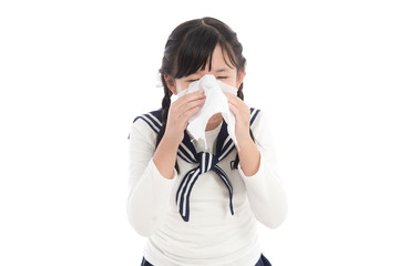 Beautiful Asian girl blows her nose on white background