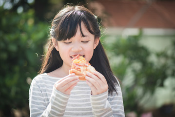 Beautiful Asian girl eating eating pizza
