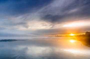 Sunrise over a misty wild river