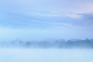 Fototapeta premium Morning over a misty blue bank of a wild river