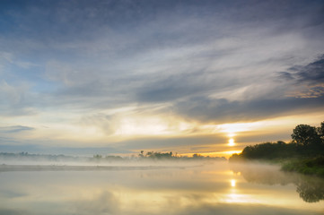 Panele Szklane  Wschód słońca nad mglistą dziką rzeką