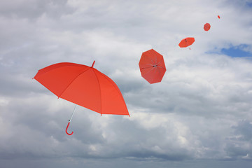 Red umbrella blown by wind.