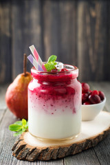 Healthy breakfast. Fresh cranberry smoothie in a glass jar on the old wooden background. Selective focus.