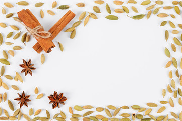 Cinnamon sticks, cardamom and star anise. Background frame of spices. Preparation for writing