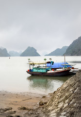 Boat sailing on Halong Bay, UNESCO world heritage site. Limestone islands protrude from the water.
