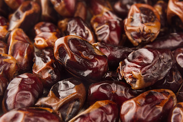 Date fruit closeup background. Heap of dried shiny brown red date fruit. Top view.