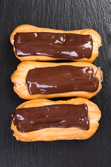 Eclairs in chocolate coating isolated on black background.