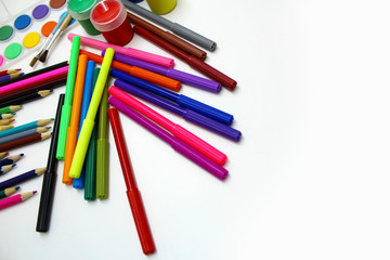 Colored pencils, markers and paint on a white background