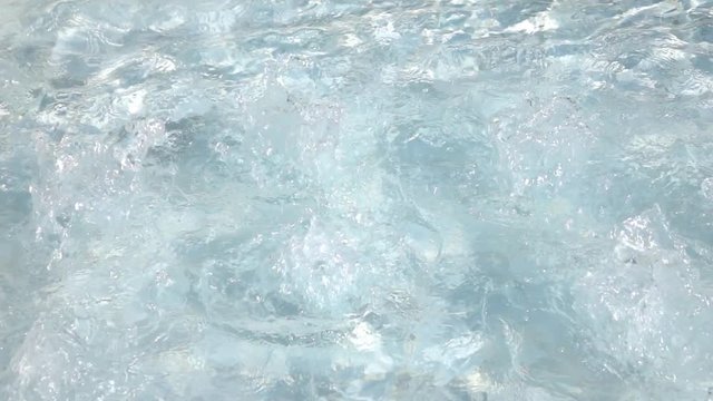 Slow motion, 240fps, of cool boiling water in whirlpool. Hydromassage in spa for health and pleasure. Play of sunshine on fountain. Beautiful natural background for amazing intro in decelerated clip.